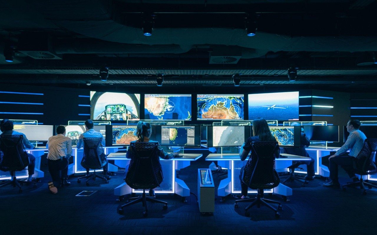 several employees working behind computers at a command center